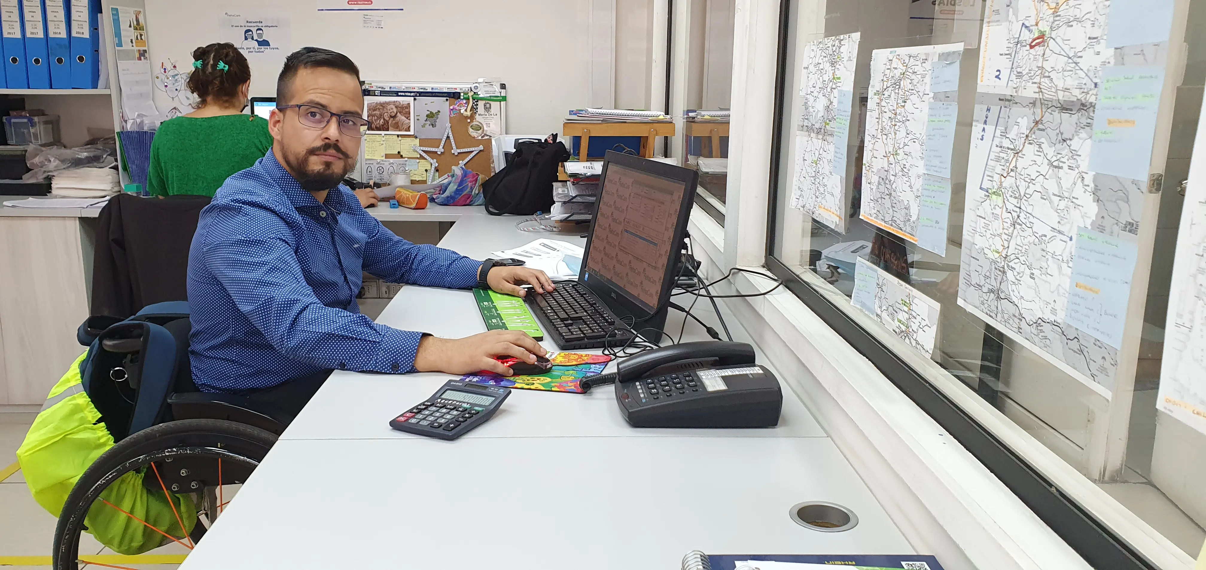 Persona en silla de ruedas trabajando frente a un computador